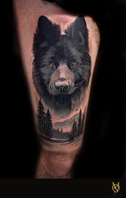 Tatouage réaliste noir et gris, loup en forêt, cuisse, par Matilda